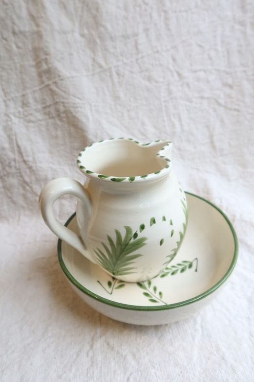 Juego de taza y plato decorado con motivos vegetales